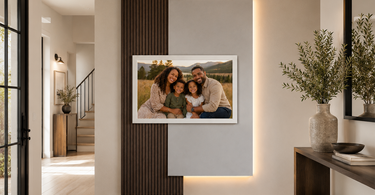 Custom family portrait wall installation with timber slats, satin gloss backing board, warm backlighting, and framed portrait in a modern entrance hall.