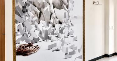 Large framed wall mural featuring two white horses running through abstract geometric blocks, installed in a bright modern corridor with glossy tiled floors and an ornate gold frame.
