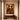 Minimalist warm-toned hallway featuring a textured plaster wall with a large framed artwork of an African couple facing each other, adorned in gold jewelery, above a wooden console table with a decorative bowl.