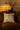 Decorative pillow with black patterns on a brown sofa in a warm-toned room.