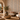 Contemporary boutique spa relaxation lounge featuring NIZARRA Axis geometric wallpaper, neutral upholstered seating, textured plaster walls, natural timber furniture and earthy decorative accents.