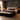Luxury boutique hotel bedroom with NIZARRA Crossline 01 Charcoal wallpaper mural behind a beige upholstered bed, complemented by burgundy accents, bedside lamps and contemporary furnishings.