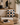 NIZARRA dot pattern cushion styled on a cream sofa in a warm neutral living room with natural wood, black accents, ceramics, greenery and layered textures.