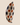 Upright side view of a NIZARRA dot pattern cushion showing cream fabric, black dotted circular motifs, warm brown accents, seam detail and structured plumpness.