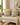 Two mustard, grey, and white Xhosa-inspired geometric cushions styled on a neutral sofa in a warm modern living room with soft natural light.