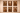 Afro-modern gallery wall featuring six framed canvas artworks arranged in a grid on a warm textured plaster wall, depicting African figures including a warrior, couples, and a woman carrying a pot, all rendered in rich earthy tones with soft, ambient lighting