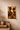 Unframed Afro-modern fine art print of The Union Sankofa III with white border, taped to a textured plaster wall with ceramic vase and natural material samples.