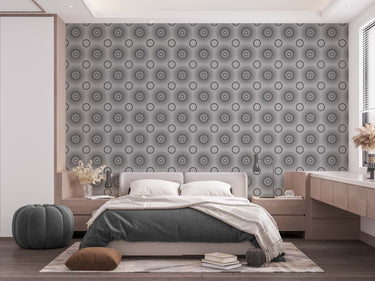 A bedroom with complete bedroom furniture and bedding. On the one wall is a wallpaper with a light grey background and dark grey circles.