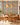 NIZARRA Zulu-inspired geometric wallpaper creating a colourful feature wall in a contemporary dining area with natural timber furniture, terracotta seating and woven pendant lights.