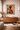 Framed African wall art ‘The Bearer – Sankofa I’ by NIZARRA displayed above a wooden sideboard in a warm stone Afro-modern living room with neutral tones and soft natural light”