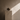 Minimalist Afro-modern still life featuring a handcrafted ceramic vessel on a stone plinth against a textured warm stone plaster wall, with soft natural light casting a diagonal shadow.