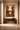 The Offering by NIZARRA, framed canvas African wall art in an Afro-modern interior above a wooden console table with warm plaster walls
