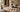 Warm Afro-modern living room with textured plaster walls, neutral furniture, natural wood, ceramic vessels, fabric samples, stone finishes, and colour palette swatches laid out for an interior design project.