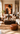 Family relaxing in a warm Afro-modern living room with neutral seating, African-inspired artwork, layered cushions, natural textures and refined styling after a NIZARRA One-Day Room Reset.
