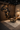 African-inspired luxury interior design featuring wood wall paneling, Africa silhouette shelving, sculptural decor, leather lounge chair, and organic coffee table in a warm, modern living space.
