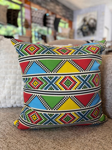 Colorful geometric patterned pillow on a couch in a living room setting