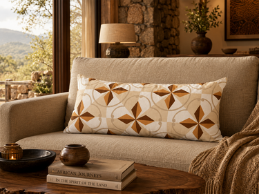 NIZARRA Basotho-inspired lumbar cushion styled in a warm luxury lodge lounge with natural textures and earthy tones.