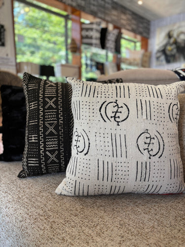 Two mud cloth patterned pillows on a couch in a living room setting.