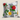 Tsonga Floral botanical cushion with red, yellow, pink and blue flowers on grey and white vertical stripes against a neutral background.