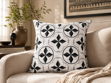 White Basotho-inspired geometric cushion styled on a textured neutral armchair with warm Afro-modern décor.