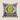 NIZARRA Ndebele scatter cushion with a bold black and white geometric pattern, yellow central motif, blue, pink and orange accents, shown on a warm neutral background.