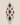 Side-profile product image of a NIZARRA cushion with black dotted circular motifs, warm brown circles, visible zip detail and balanced plump shape on a neutral background.