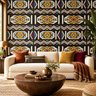 NIZARRA Ndebele-inspired geometric wallpaper displayed behind a cream sofa with terracotta and burgundy cushions, a dark timber coffee table and a natural woven rug.