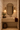 Compact guest WC featuring NIZARRA Pulse geometric wallpaper on all walls, with burgundy circular motifs, ochre detailing, a floating travertine basin and bronze-framed mirror.