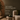 NIZARRA Room Diagnosis service graphic showing a warm, moody interior with a textured cream chair, olive cushion, stone side table and sculptural décor.