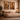 Framed African wall art ‘The Warrior’ and ‘The Bearer – Sankofa I’ by NIZARRA displayed above a neutral-toned bed in a warm Afro-modern bedroom with stone plaster walls and soft ambient lighting
