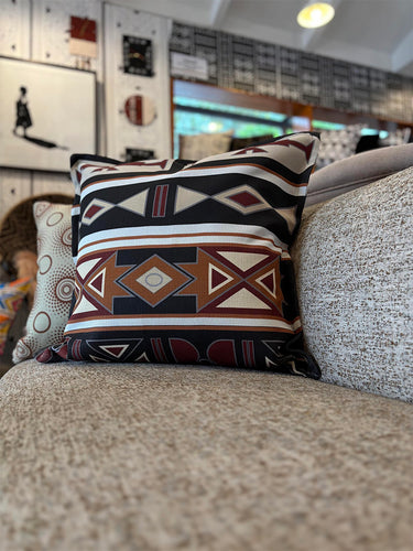 NIZARRA Sepedi-inspired geometric cushion styled on a textured neutral sofa in a relaxed interior setting.