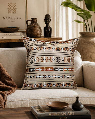 Sepedi-inspired geometric cushion styled on a cream armchair in a warm Afro-modern living room with earthy decor.