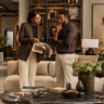 NIZARRA designer helping a client compare fabric samples and furniture options in a refined interior showroom before making a purchase.