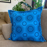 Blue pillow with circular pattern on a brown couch in a living room setting