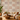 NIZARRA Terra Rhythm wallpaper on a contemporary living room feature wall, featuring clay, rust and grey geometric motifs with a cream sectional sofa and wooden coffee table.
