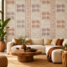 NIZARRA Terra Rhythm wallpaper on a contemporary living room feature wall, featuring clay, rust and grey geometric motifs with a cream sectional sofa and wooden coffee table.