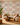 NIZARRA Terra Rhythm wallpaper on a contemporary living room feature wall, featuring clay, rust and grey geometric motifs with a cream sectional sofa and wooden coffee table.