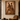 Framed Sankofa artwork “The Passage” displayed in a luxury Afro-modern interior, featuring a couple walking forward in earthy ochre and brown tones, set against a warm stone plaster wall with a leather lounge chair and wooden table.
