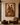 Framed Sankofa artwork “The Passage” displayed in a luxury Afro-modern interior, featuring a couple walking forward in earthy ochre and brown tones, set against a warm stone plaster wall with a leather lounge chair and wooden table.
