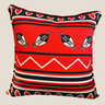 Front view of a red, black and white Swazi-inspired cushion with shield motifs, stripe detailing and a bold white zigzag pattern on a neutral background.