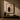 Framed minimalist art print featuring a sculptural vase silhouette on a warm plaster wall, styled with ceramic objects on a low wooden bench in an Afro-modern interior setting.