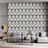 Xhosa inspired wallpaper geometric triangular dark grey, light grey, white on a wall in a  living room setting.