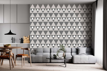 Xhosa inspired wallpaper geometric triangular dark grey, light grey, white on a wall in a  living room setting.