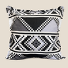 Black, white and grey Zulu-inspired geometric cushion with beadwork-style diamond and chevron patterns on a warm neutral background.