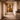 Framed African wall art ‘The Bearer – Sankofa I’ by NIZARRA displayed at the end of a warm stone hallway with natural light, wooden flooring, and minimal Afro-modern styling