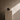 Minimalist Afro-modern still life featuring a handcrafted ceramic vessel on a stone plinth against a textured warm stone plaster wall, with soft natural light casting a diagonal shadow.