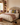Neatly made bed with decorative pillows and a blanket in a NIZARRA Style bedroom setting.